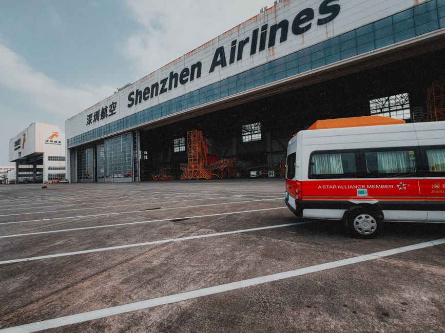 A charter bus parked outside an airport terminal for a group transfer