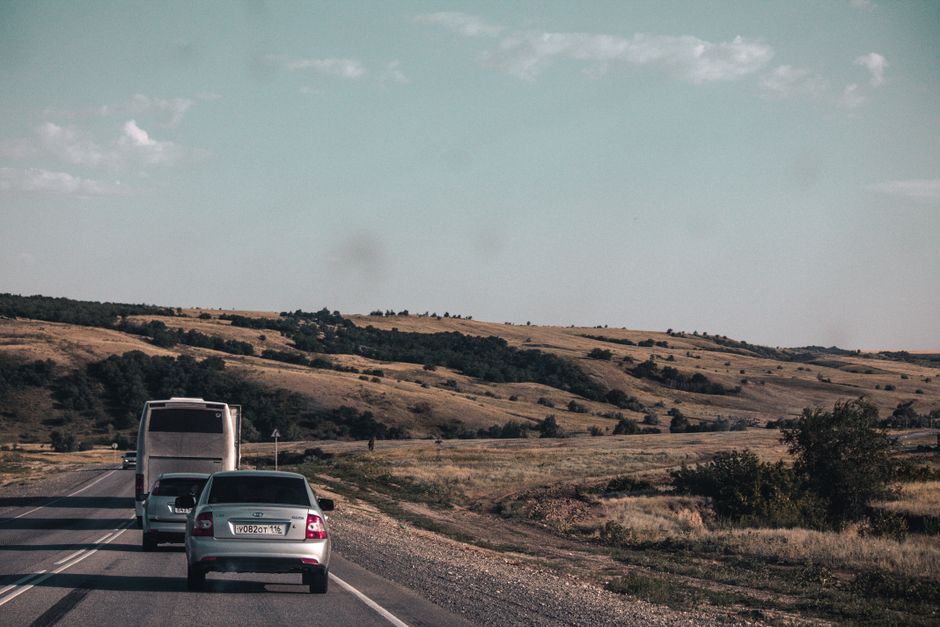 A charter bus traveling on a long highway during a long-distance group trip