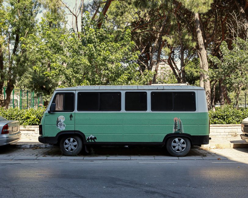 A full-size charter bus parked next to a smaller mini bus, illustrating the size difference between the two rental options