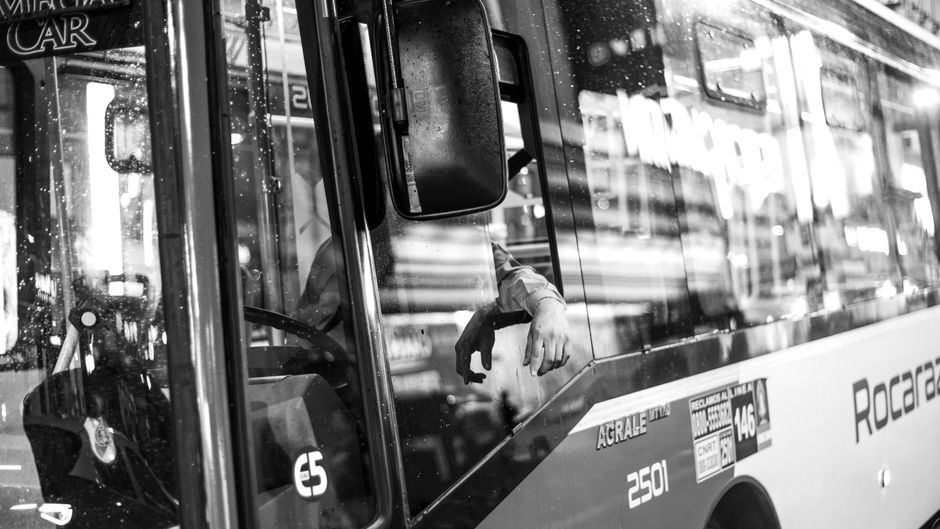 Charter bus driver standing beside a bus preparing for a group trip