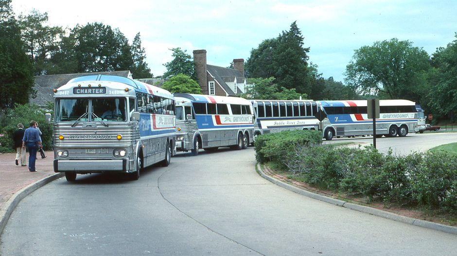 Charter bus driver standing beside bus with group boarding for a multi-day trip