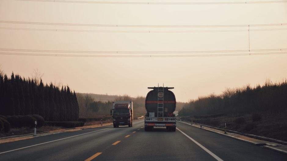 Charter bus driving on a highway representing fuel efficiency factors affecting trip cost