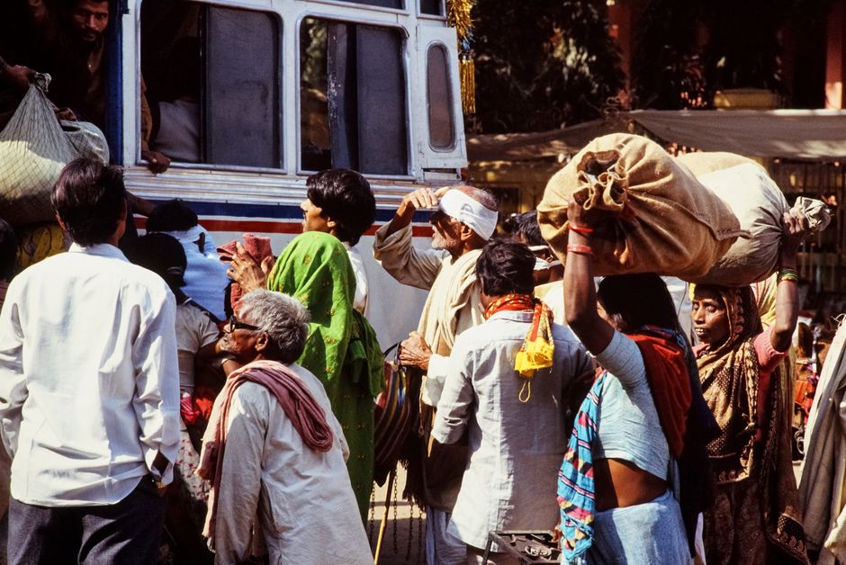 Charter bus parked at a curbside pickup and drop-off location with passengers boarding