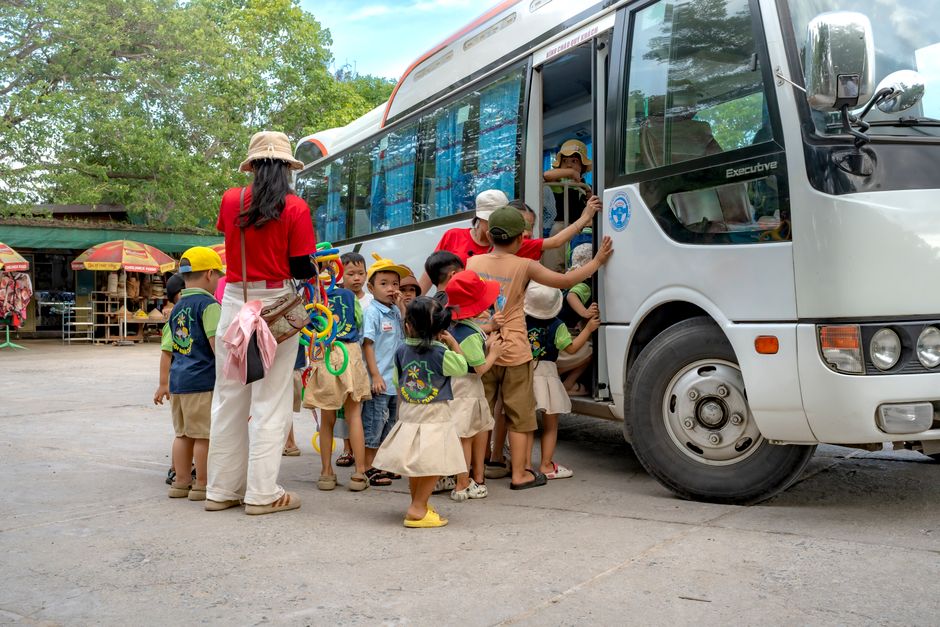 Charter bus parked outside a museum entrance as a group prepares to board for a museum trip