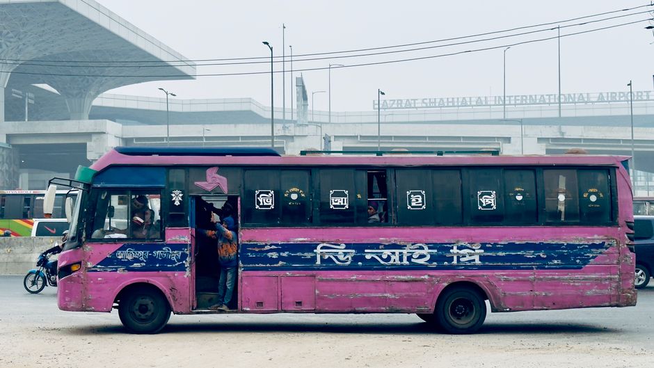Charter bus parked outside an airport terminal picking up passengers for a hotel transfer