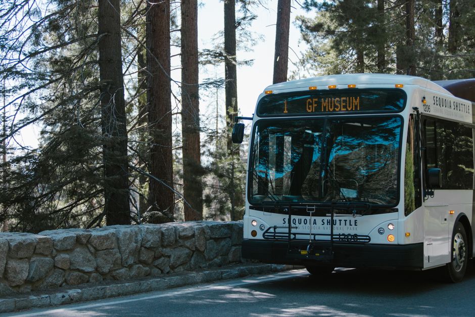 Charter bus picking up passengers at an airport parking shuttle stop