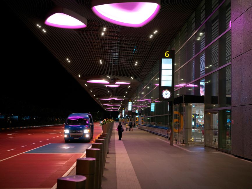Charter bus picking up travelers at an airport parking shuttle stop
