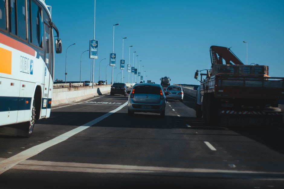 Charter bus traveling on a multi-lane highway near an HOV lane sign