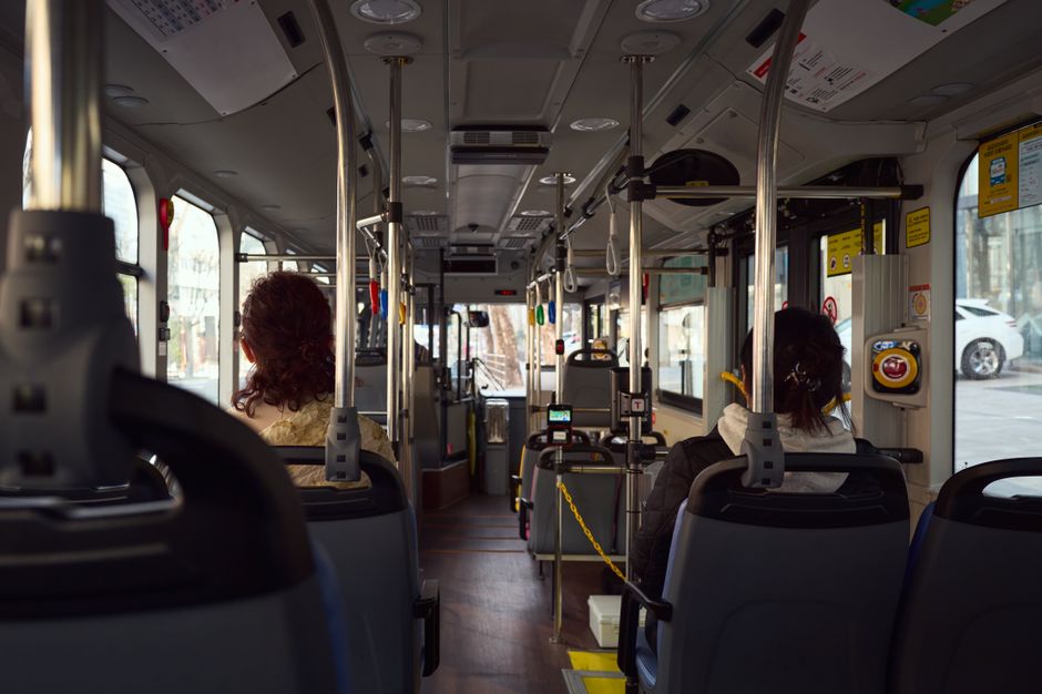 Interior of a charter bus showing rows of comfortable reclining seats and amenities included in a rental
