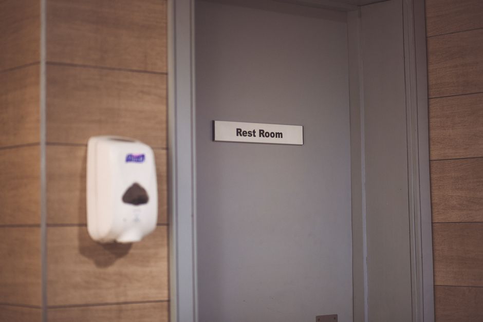 Interior view of a charter bus restroom located at the rear of the coach