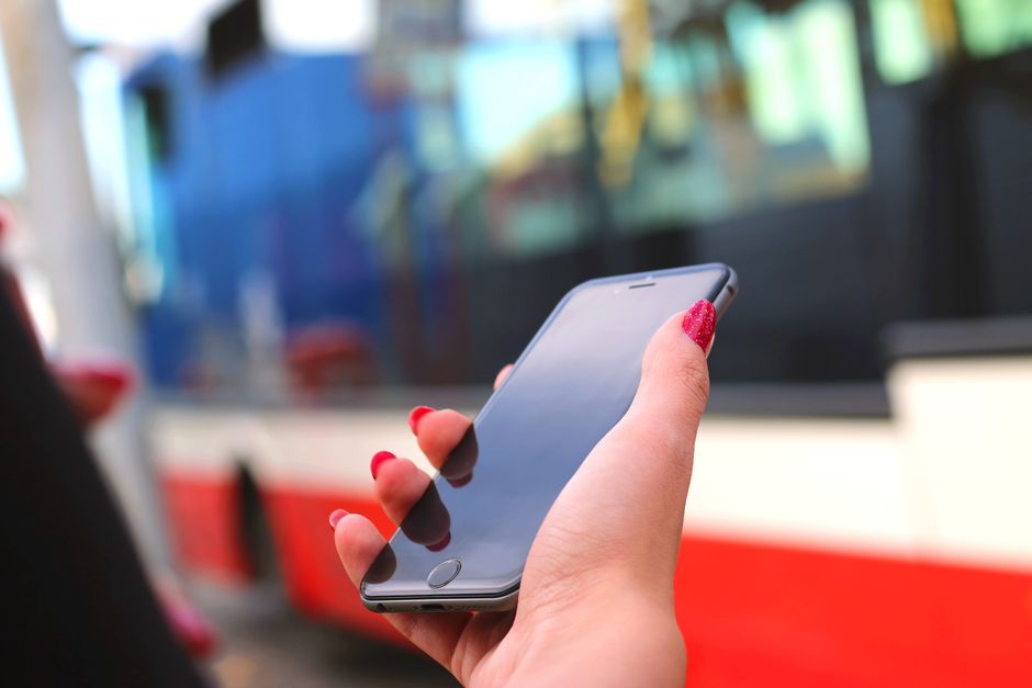 Passenger charging a smartphone using a USB outlet on a charter bus seat