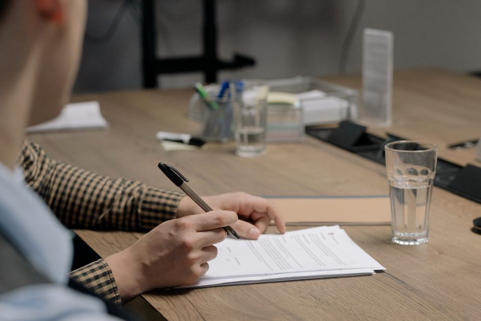 Person reviewing a charter bus rental contract with a motorcoach parked in the background