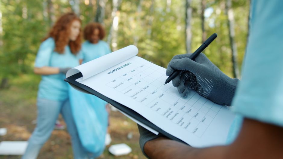 Printable charter bus booking checklist on a clipboard next to a parked charter bus