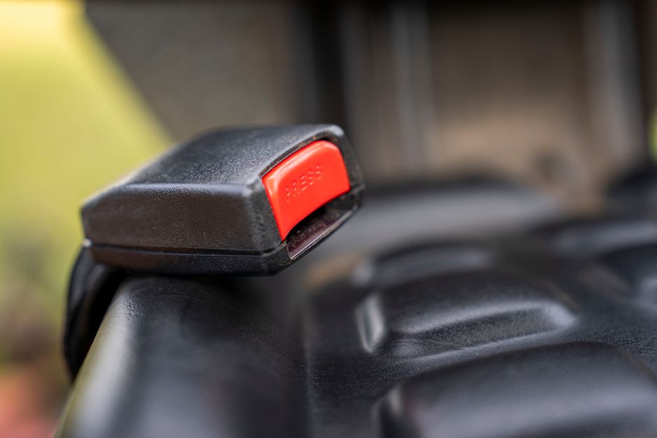 Rows of charter bus seats showing installed seat belts for passenger safety
