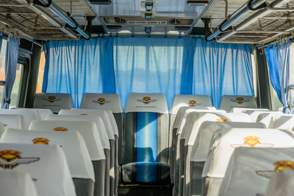 Rows of empty seats inside a charter bus prepared for a large group trip