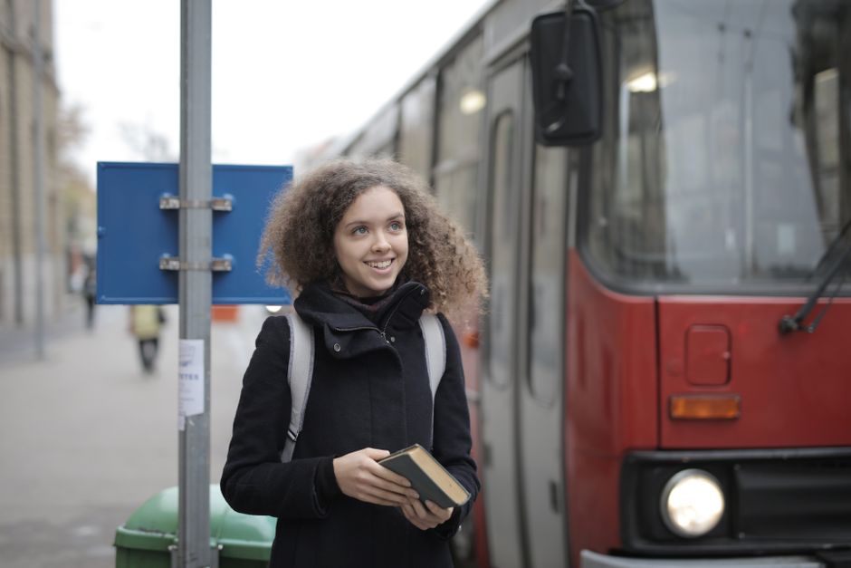 Travel coordinator confirming a charter bus booking on a laptop with a bus parked outside