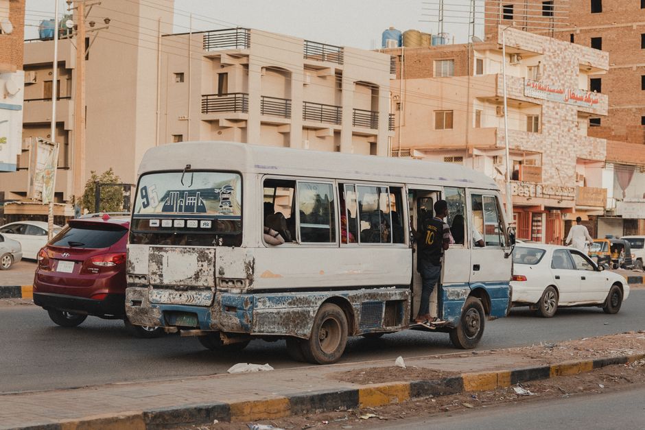 White charter minibus parked outside, ready to transport a group of 20 passengers