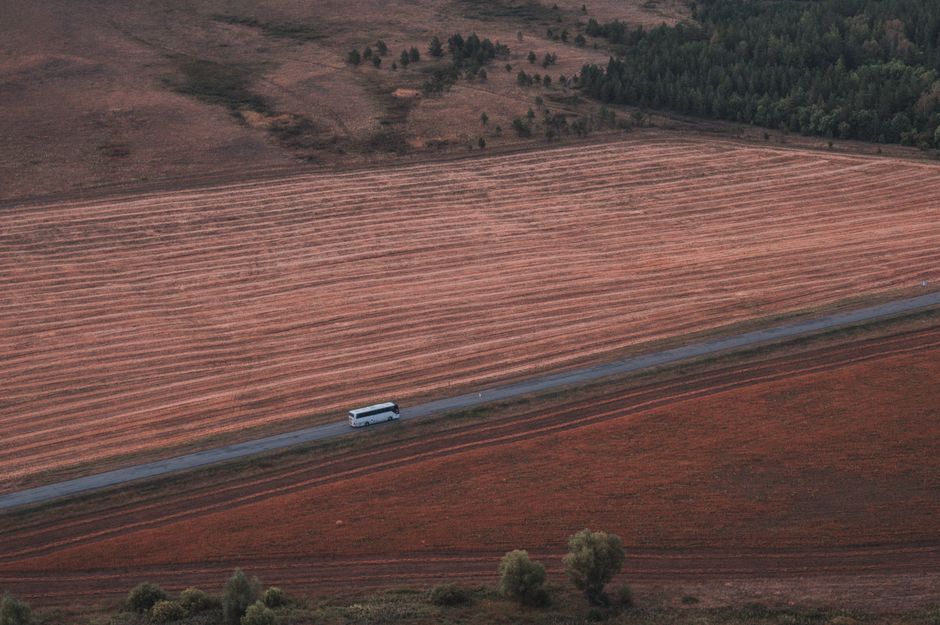 A charter bus traveling along a scenic southern highway during a large group road trip