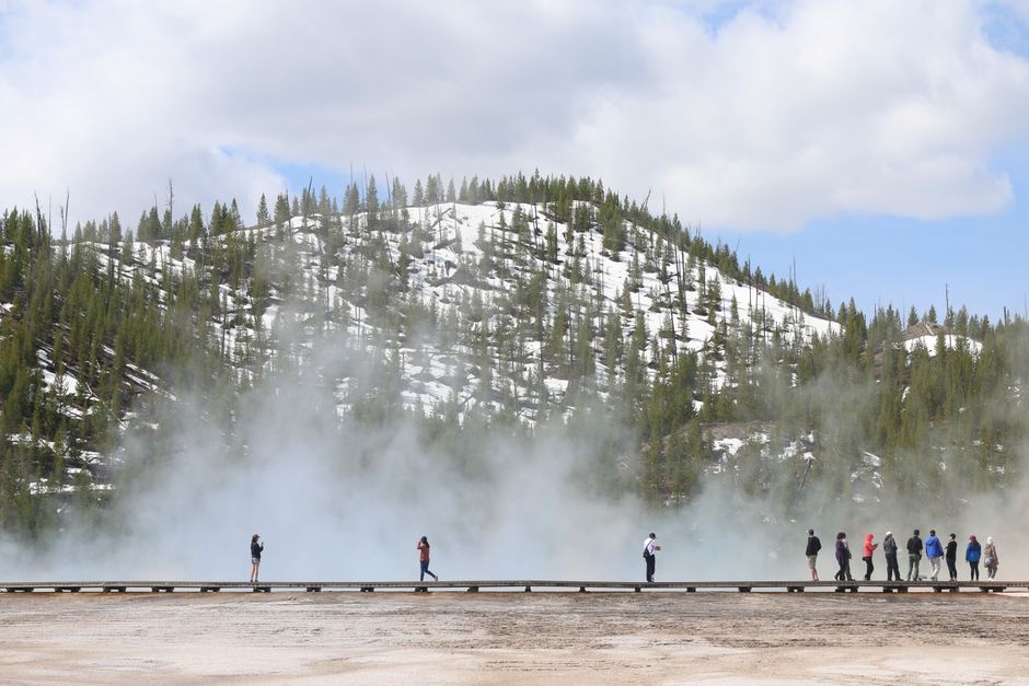 A large group of hikers walking together on a scenic national park trail
