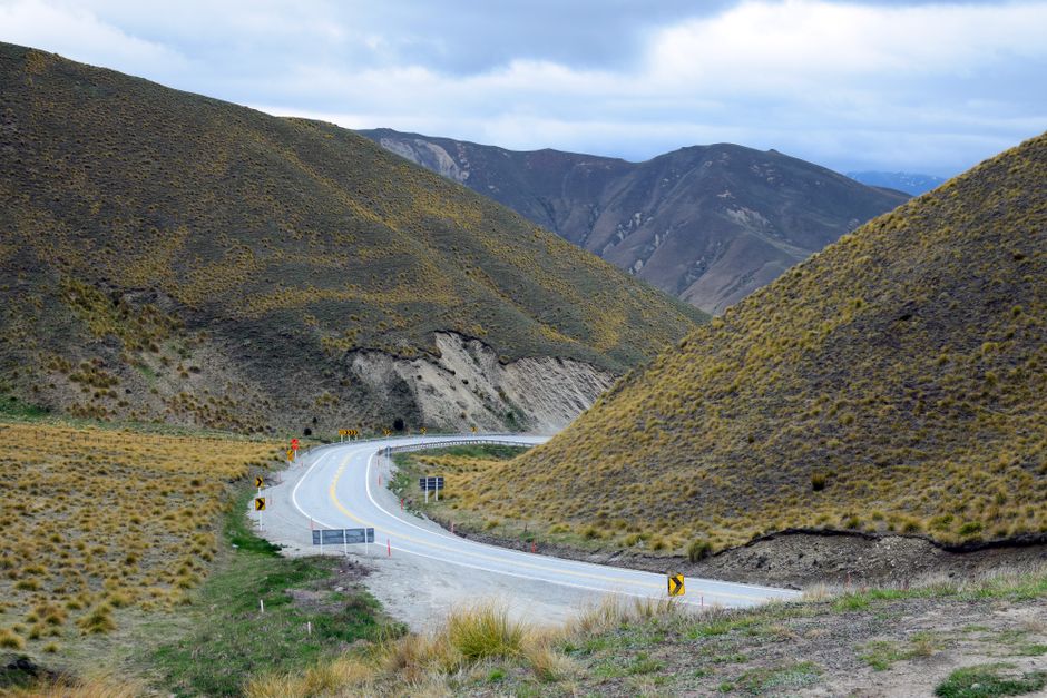 Charter bus driving along a scenic southern highway with mountains in the background, representing a large group road trip route
