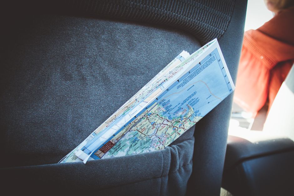 Charter bus parked with a multi-city travel route map illustrating group tour planning