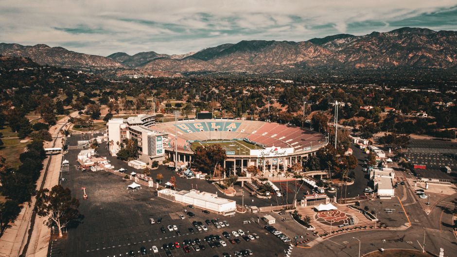 Fans tailgating outside a packed college football stadium before a game