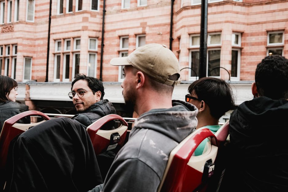 Group of friends splitting the cost of a charter bus rental before boarding for a trip