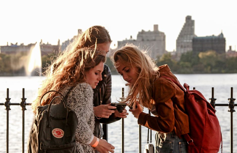 Group of tourists sightseeing in New York City with the skyline in the background