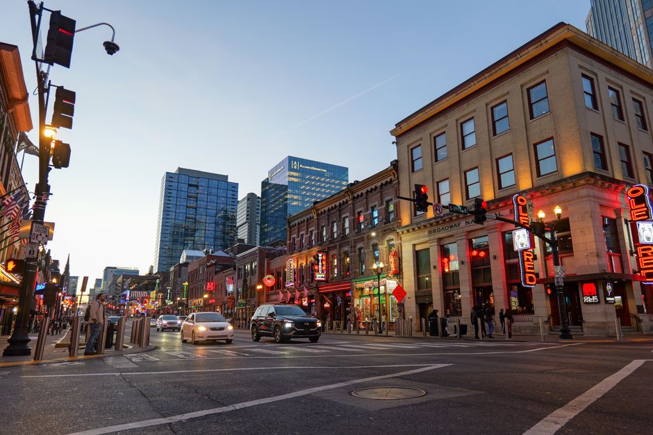 Group of travelers walking down Broadway in Nashville, Tennessee, past honky-tonk bars and live music venues