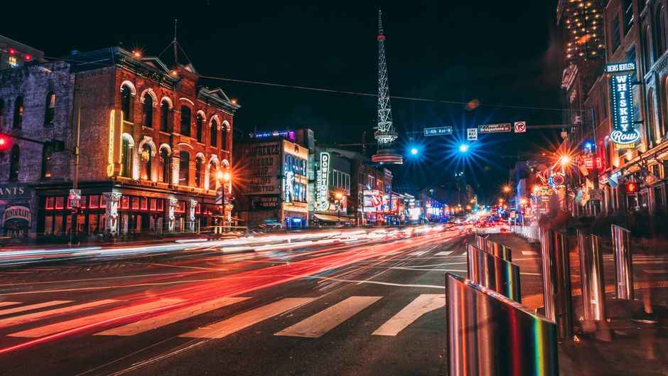 Large group of tourists walking down Broadway in downtown Nashville past honky-tonk bars