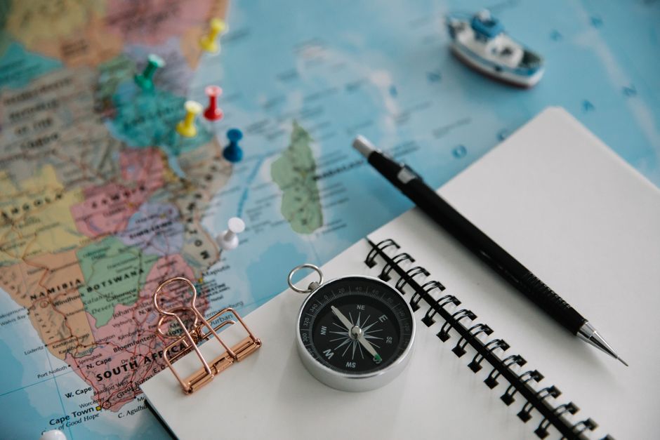 Traveler planning a state-specific group trip itinerary using a map and travel guides