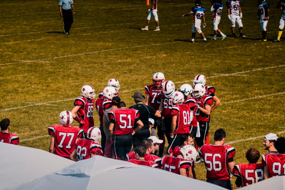 Youth sports team loading equipment onto a charter bus for a budget group travel trip