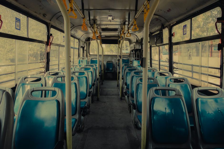 Interior view of a modern luxury charter bus showing reclined leather seats and ambient lighting